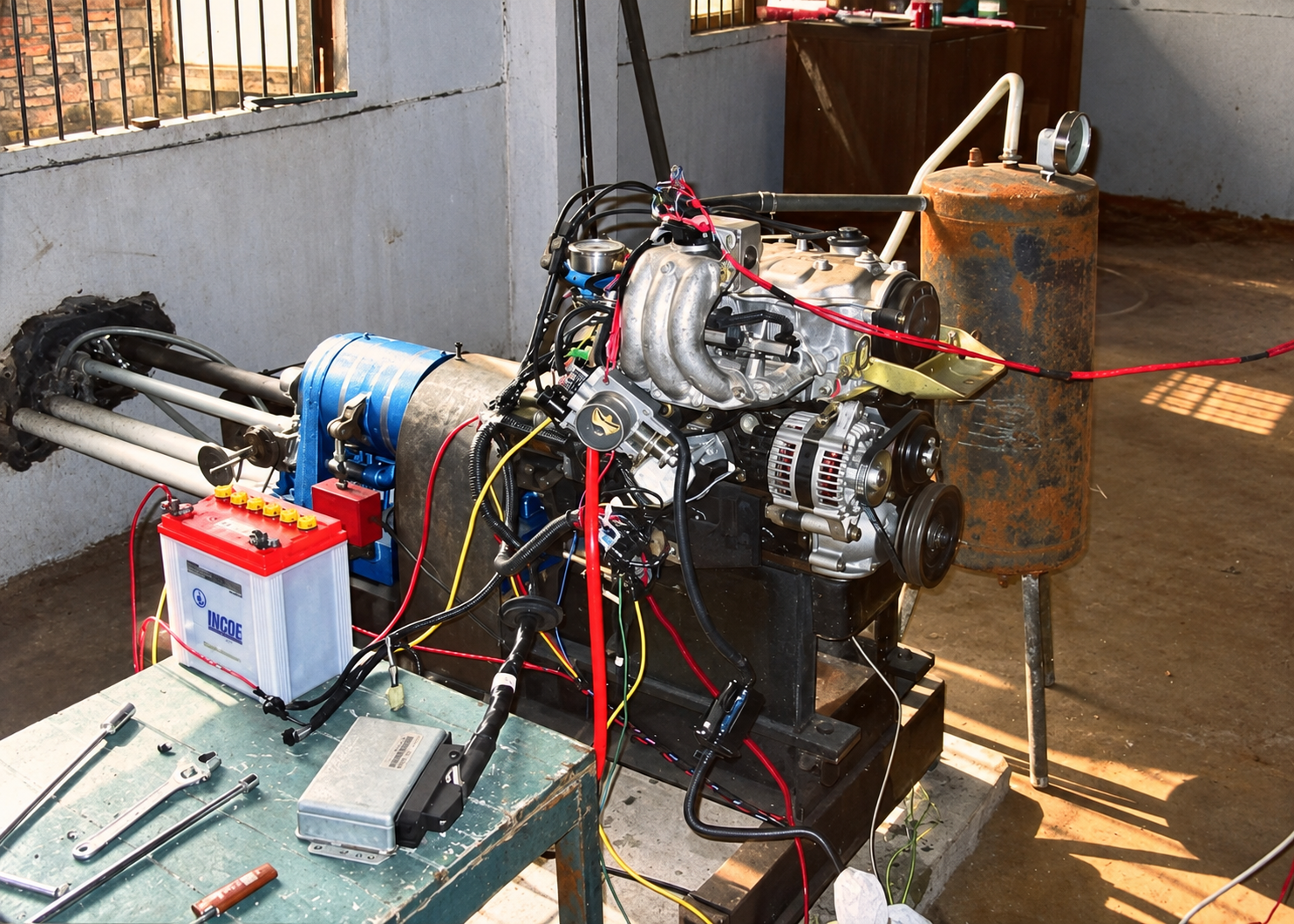 An engine test setup connected to wiring harnesses and a controller in a workshop