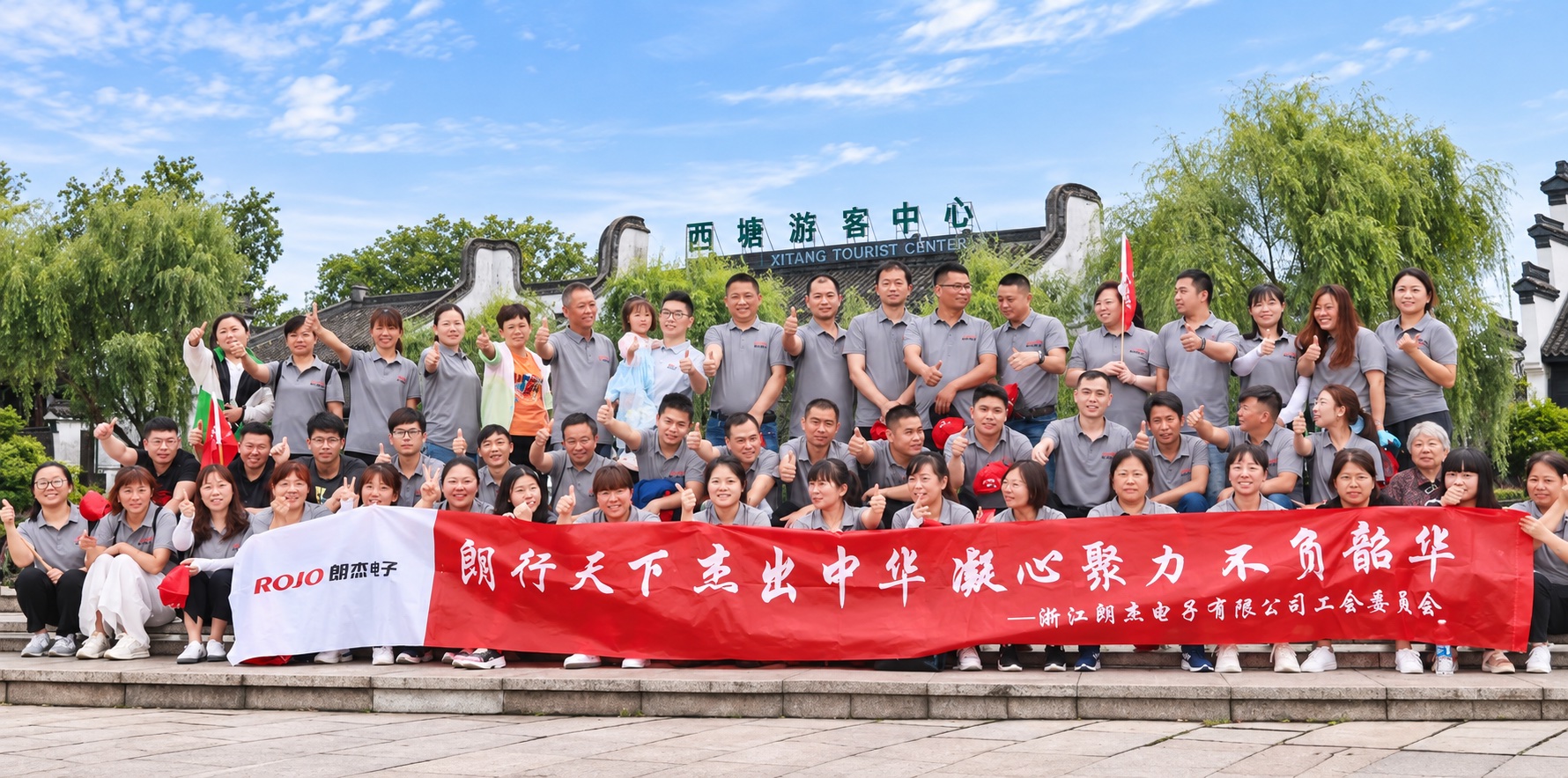 Langjie employees holding a company event banner in front of the Xitang Visitor Center